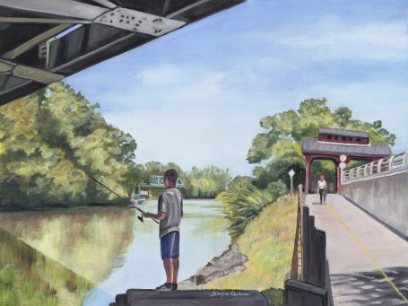 Fishing Erie Canal A boy fishing by a river under a bridge, with trees and a path nearby.